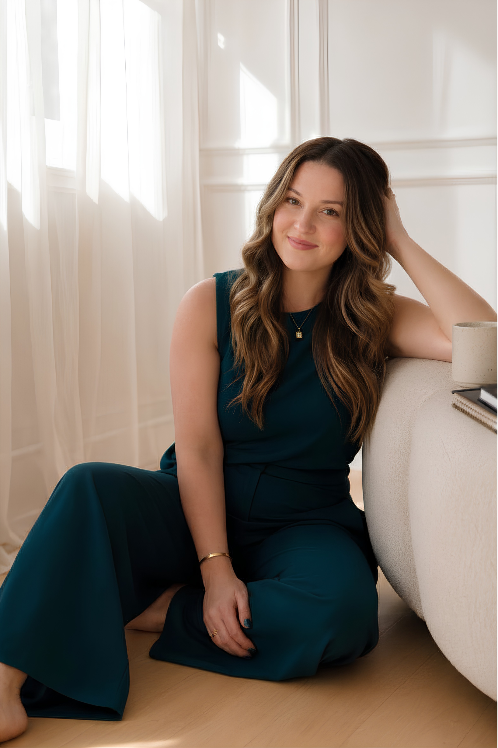 Marybeth Welty, who builds AI employees for women entrepreneurs, sitting in a sunlit room in a teal jumpsuit